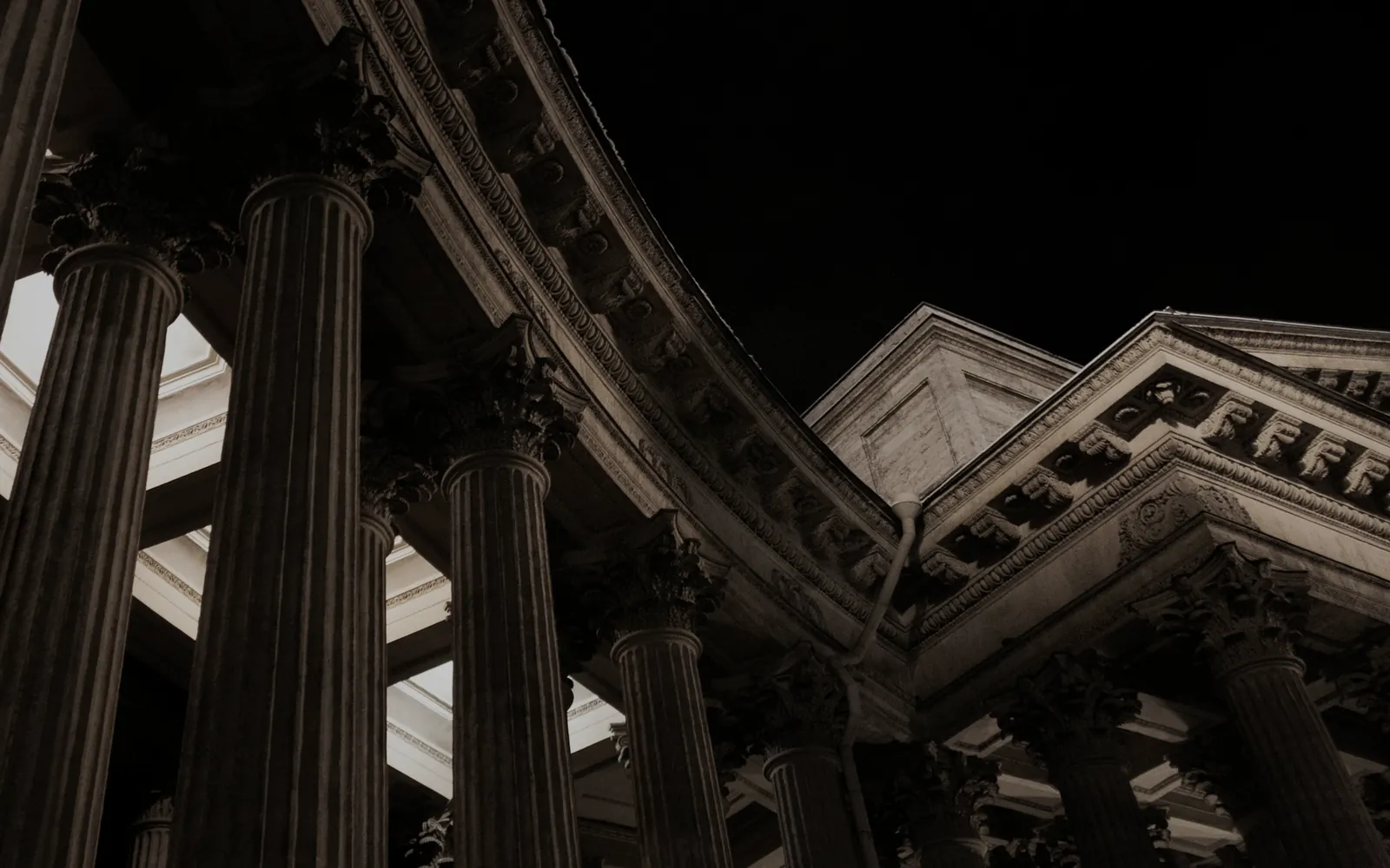 Classical stone columns at night, seen from below