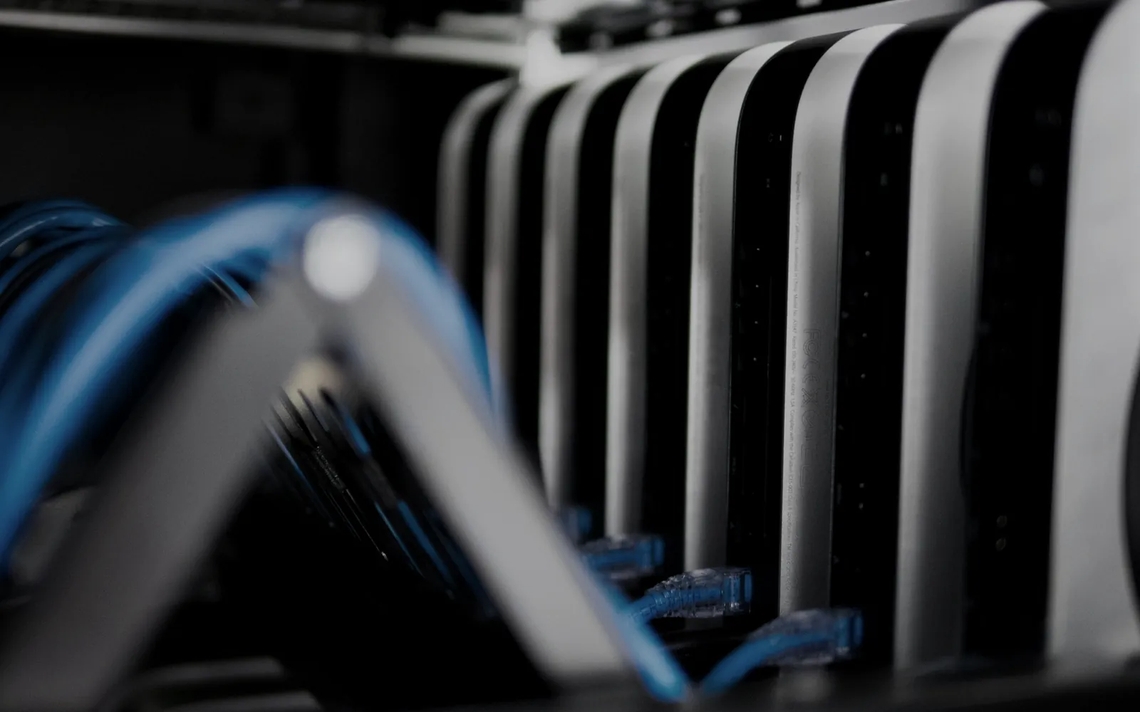 Blue patch cables plugged into a dark network rack