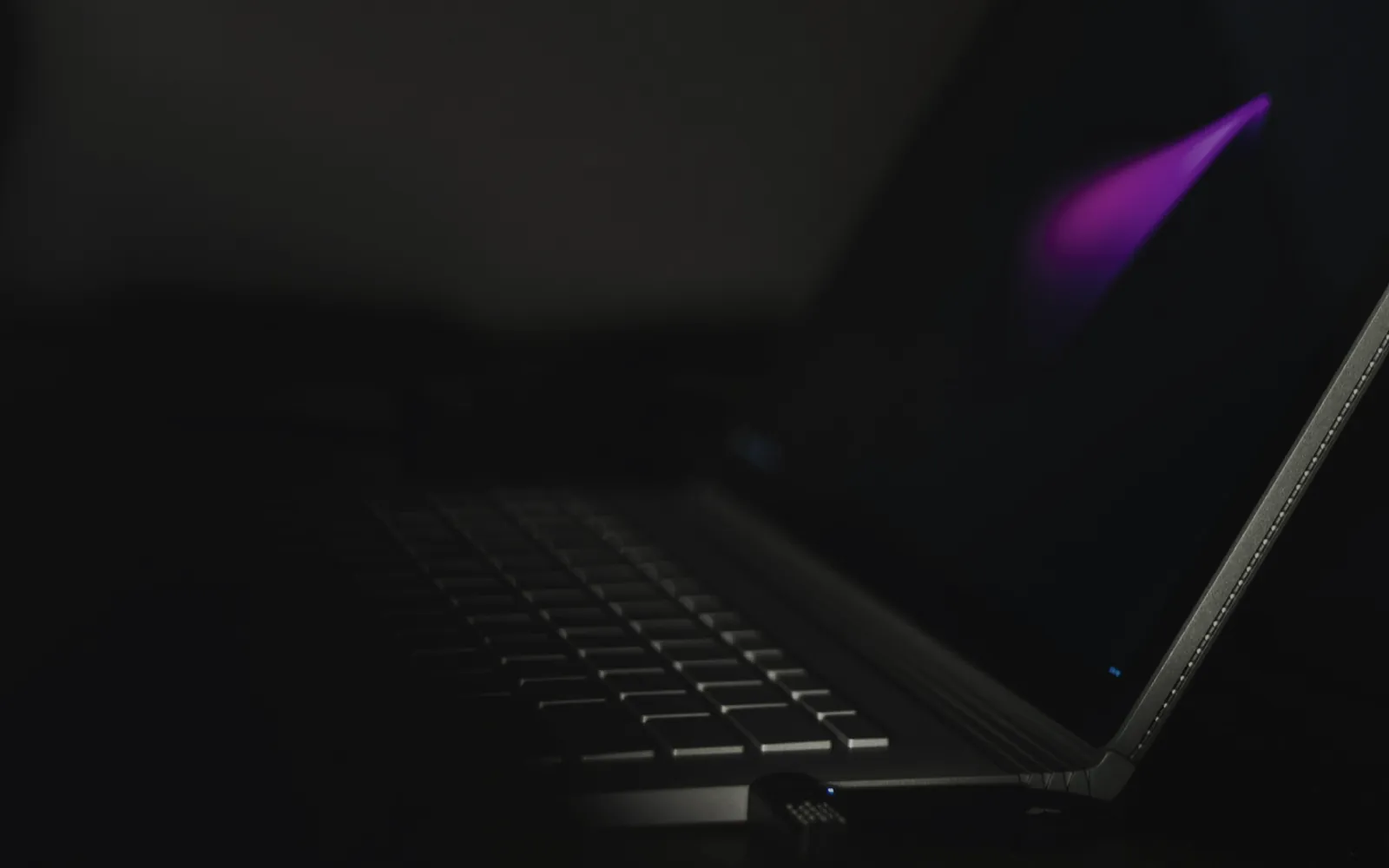 USB flash drive plugged into a laptop in the dark