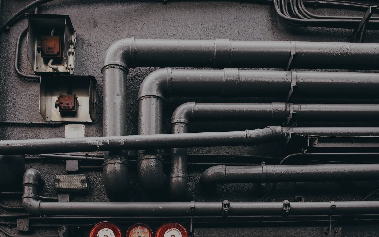 Industrial pipes and valves in a dark plant