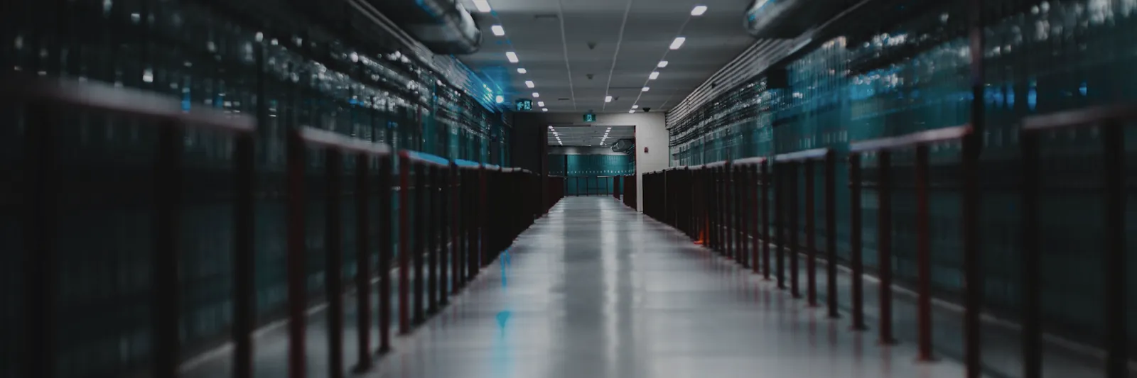 Long aisle of server racks in a dark data centre