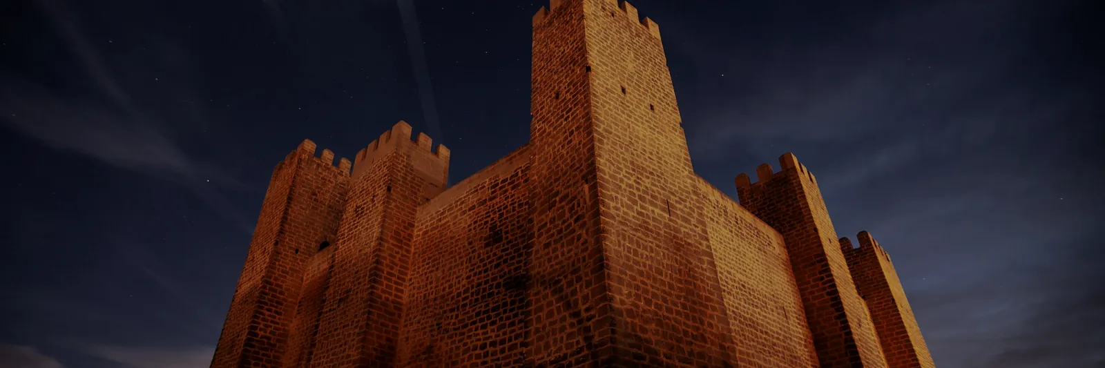 Fortress tower wall under a night sky